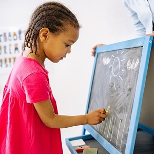 niña escribiendo en el pizarron