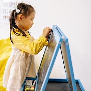 niña escribiendo en el pizarron